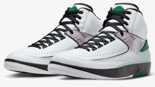 Side view of white, green, and black Air Jordan shoes.